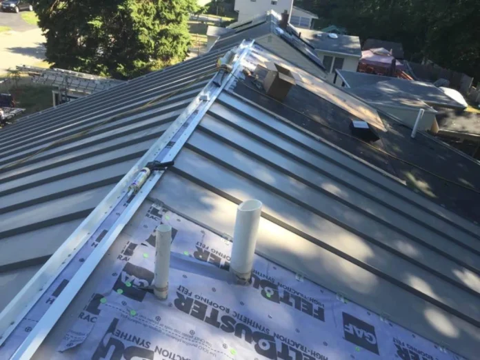 Close-up of metal roof coping installed on a flat roof parapet wall, showing a sleek, protective cap directing water away from the structure.